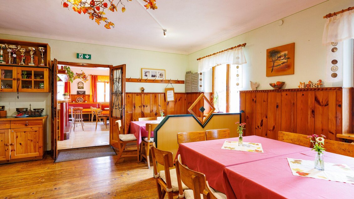 Ein gemütliches Restaurant mit Holzvertäfelung und bunten Tischdecken. Die freundliche Atmosphäre wird durch dekorative Elemente und Lichtquellen unterstützt. | © TV Region Graz-Harry Schiffer