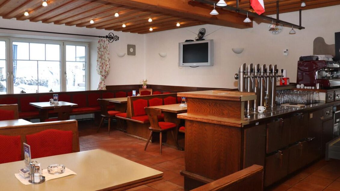 Ein einladendes Restaurant mit holzbeplankter Decke und roten Sitzen. Die Atmosphäre ist gemütlich und rustikal. | © Steirische Rucksackdörfer