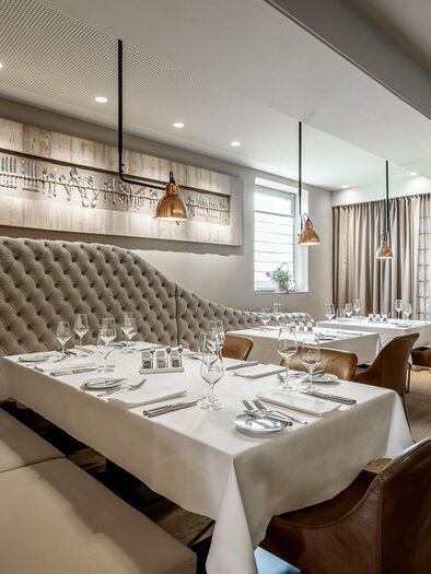 Ein elegantes Restaurant mit modernen Möbeln und stilvollem Dekor. Die Tische sind für Gäste gedeckt und eine angenehme Atmosphäre ist sichtbar. | © Bernhard Janko