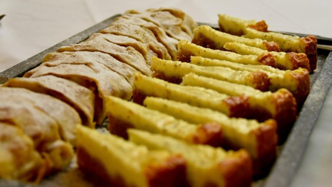 Ein Tablett mit zwei Arten von Kuchen und Gebäck. Die eine Seite zeigt flache Stücke, während die andere Seite in quadratische Portionen geschnitten ist. | © Familie Koschak