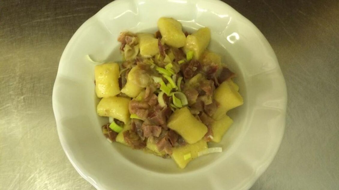 Ein Teller mit Gnocchi, garniert mit Schinken und Lauch. Das Gericht ist einfach und ansprechend serviert. | © Familie Koschak