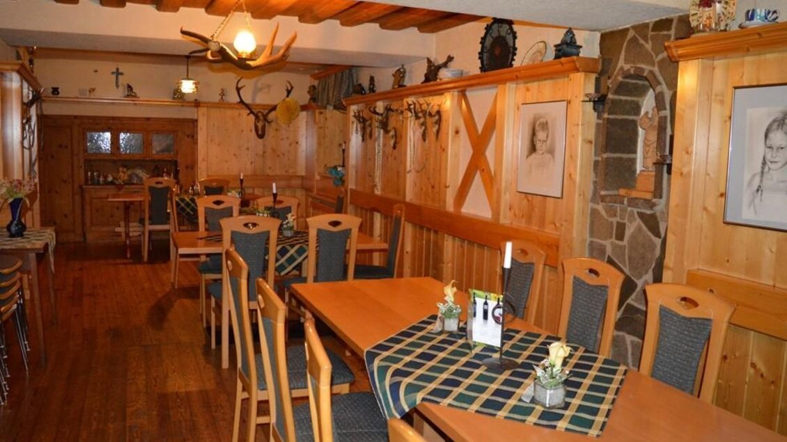 Ein gemütliches Restaurant mit Holztischen und -bänken. Die Wände sind rustikal dekoriert und schaffen eine warme Atmosphäre. | © Gasthaus  Ruckenstuhl