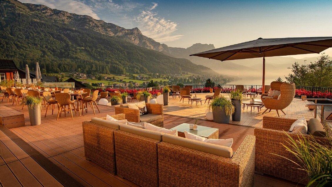 Eine gemütliche Terrasse mit Blick auf die Berge und weite Landschaft. Holzstühle und -tische bieten eine einladende Atmosphäre zum Entspannen. | © Mondi Hotel
