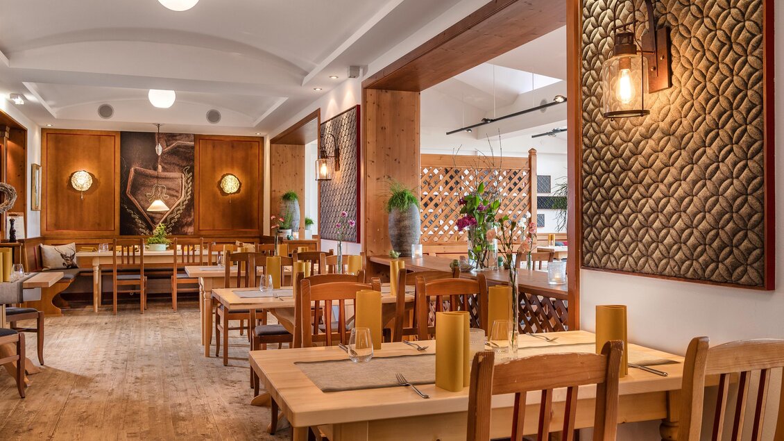 Ein modernes Restaurant mit Holzmöbeln und stilvollen Wanddekoren. Die Atmosphäre ist gemütlich und einladend.