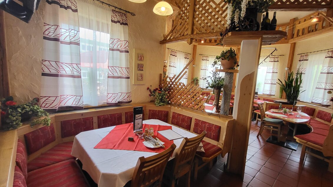 Ein gemütliches Restaurant mit Holzmöbeln und roten Polstern. Tische sind rustikal gedeckt, und das Ambiente ist einladend. | © TV Hochsteiermark