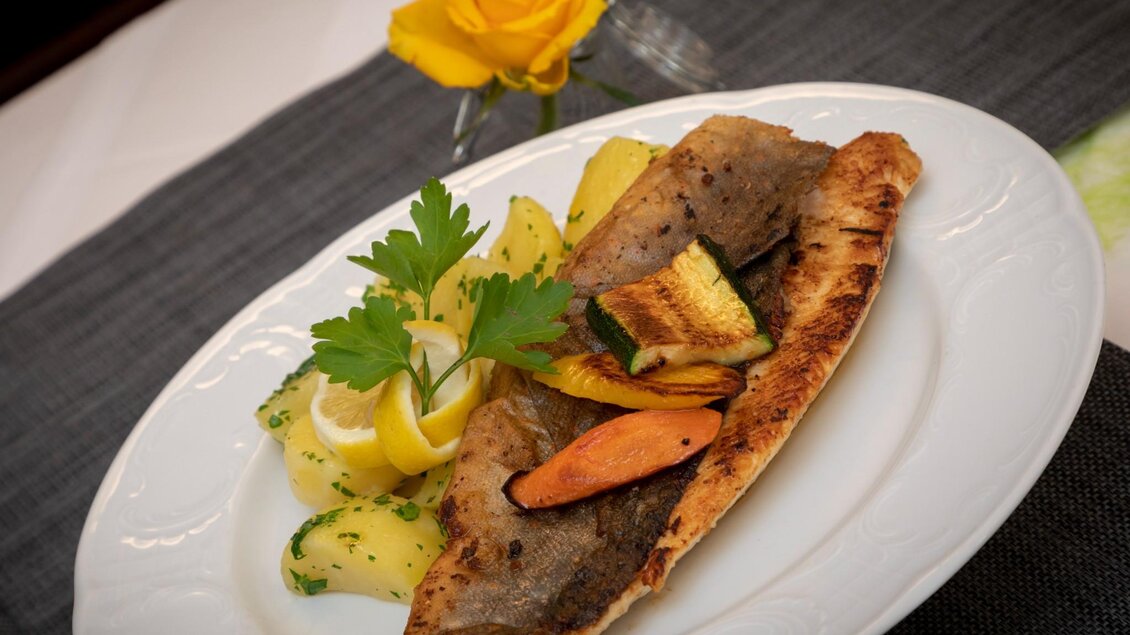 Ein schön angerichteter Teller mit gebratenem Fisch und Gemüse. Dazu gibt es eine Beilage aus Kartoffeln und frischen Kräutern. | © TV Region OberGraz - Lunghammer