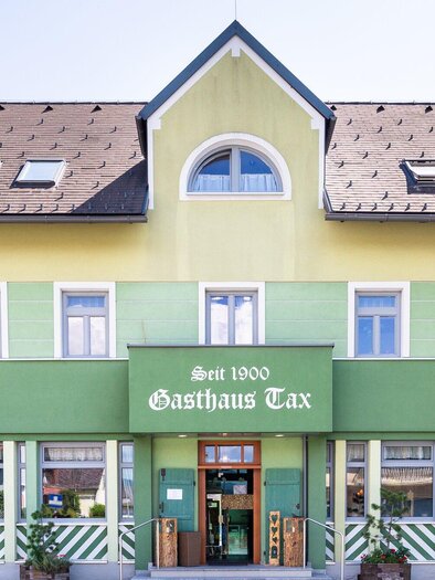 Ein charmantes Gasthaus mit grüner Fassade und einem einladenden Eingang. Das Gebäude strahlt eine freundliche Atmosphäre aus und liegt in einer malerischen Umgebung. | © Geopho