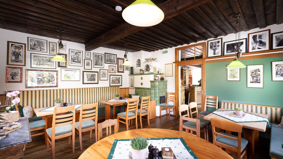Ein gemütliches Restaurant mit Holzdecke und gemütlichen Tischen. An den Wänden hängen zahlreiche Bilder, die das Ambiente auflockern. | © Geopho