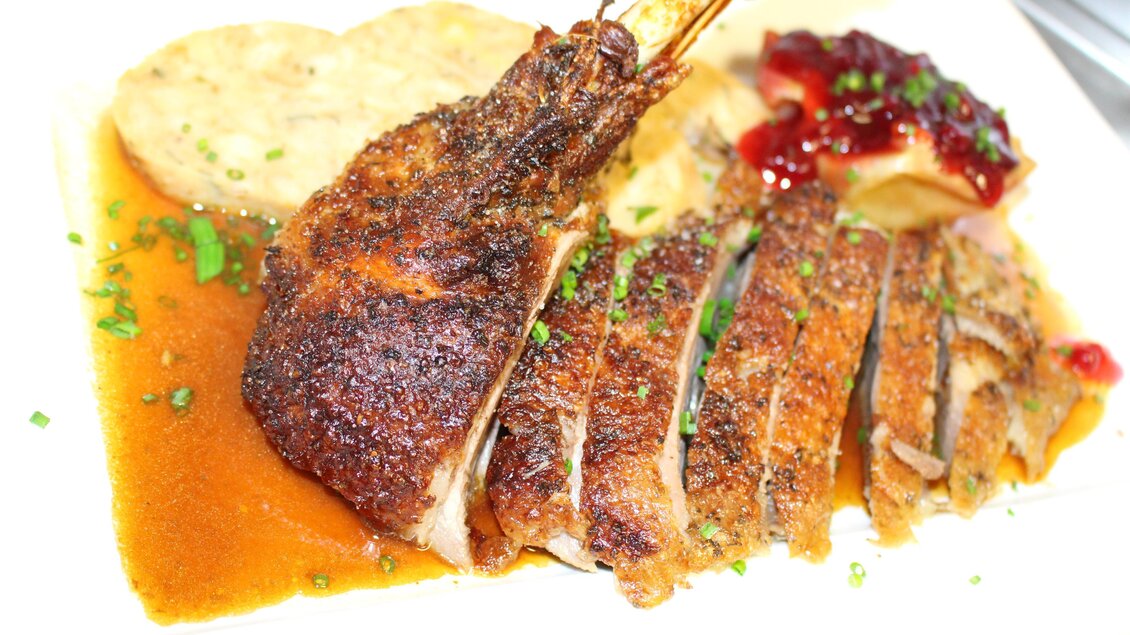 Ein köstliches Gericht mit knusprig gebratenem Fleisch, serviert mit einer aromatischen Sauce. Dazu gibt es Beilagen wie Kartoffelknödel und eine fruchtige Sauce. | © Gasthaus zur Alten Press