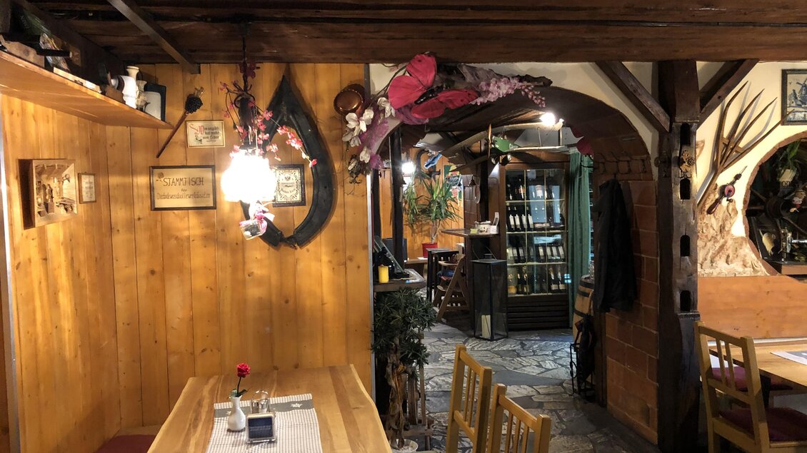 Ein gemütliches Restaurant mit Holzdekor und warmem Licht. Im Hintergrund sind Pflanzen und Bücherregale sichtbar. | © Gasthaus zur Alten Press