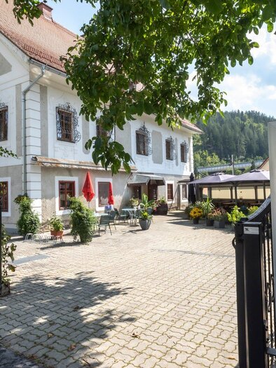 An inviting hotel with a beautiful facade and colorful flowers. A sign reading "Welcome" stands in the foreground. | © TV Region Graz - Lunghammer