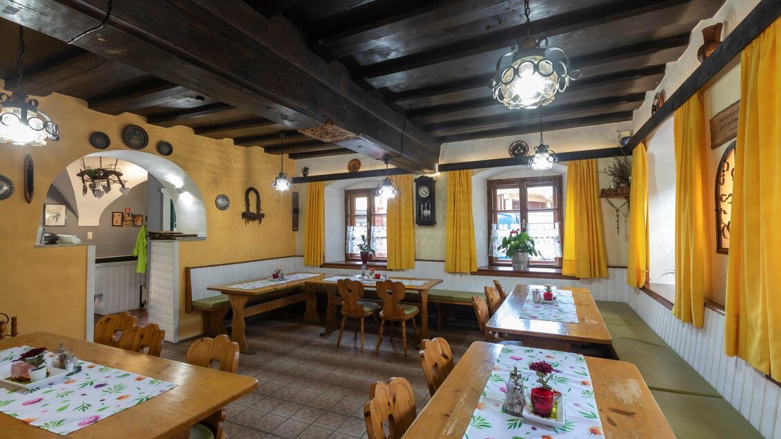 Ein gemütliches Restaurant mit Holztischen und Stühlen. Die Wände sind gelb gestrichen und mit Fenstern und Vorhängen dekoriert. | © TV Region Graz - Lunghammer