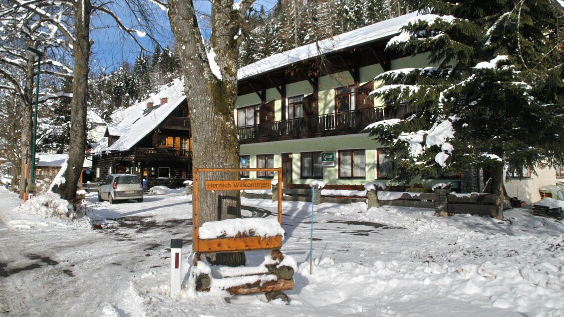 Ein malerisches Gebäude im Schnee, umgeben von Bäumen. Die Landschaft strahlt eine ruhige, winterliche Atmosphäre aus. | © Gasthof Beren "Jägerheim"