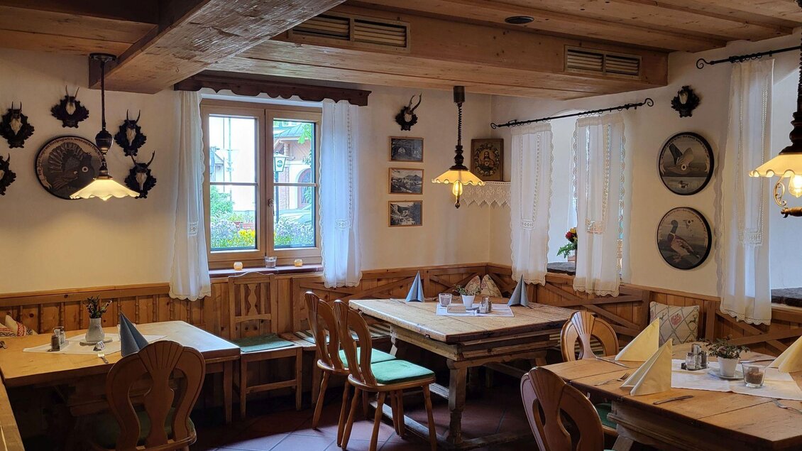Ein gemütliches Restaurant mit Holzmöbeln und warmem Licht. An den Wänden hängen dekorative Teller und Bilder. | © Petra Kirchschlager