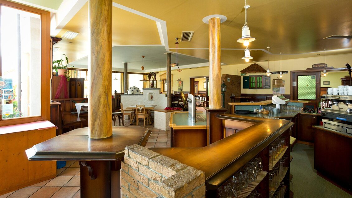 Ein gemütliches Restaurant mit einer einladenden Theke und warmen Farben. Es gibt Tische und Stühle, die eine entspannte Atmosphäre schaffen. | © TV Region Graz - Rene Vidalli