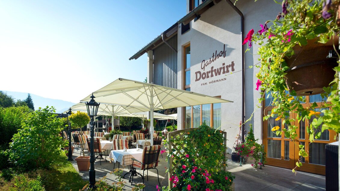Ein einladendes Restaurant mit einer schönen Terrasse, umgeben von üppigem Grün. Sonnenschirme und Tische laden zum Verweilen ein. | © TV Region Graz - Rene Vidalli