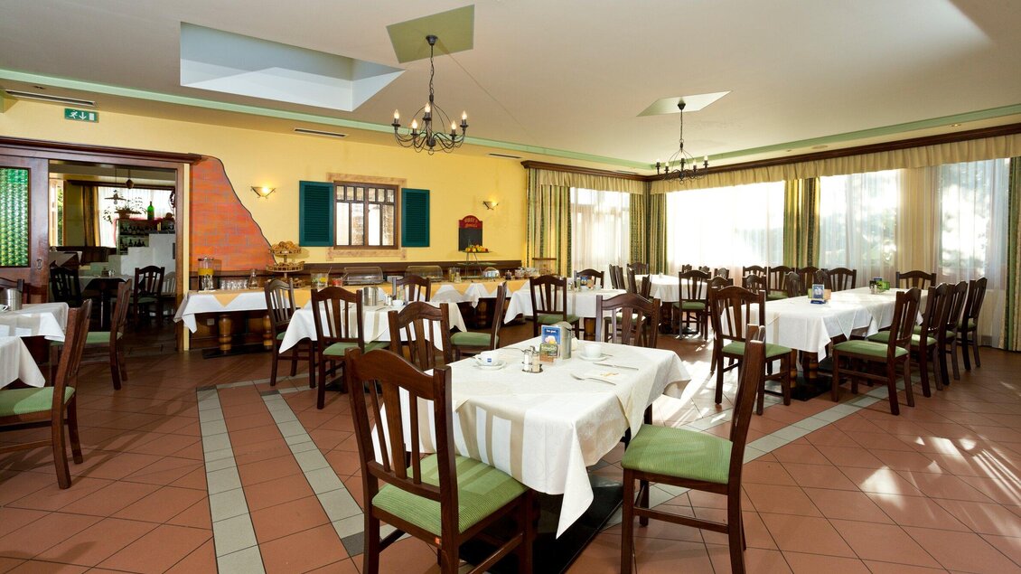 Ein gemütliches Restaurant mit weißen Tischdecken und Holzmöbeln. Große Fenster sorgen für viel Tageslicht. | © TV Region Graz - Rene Vidalli