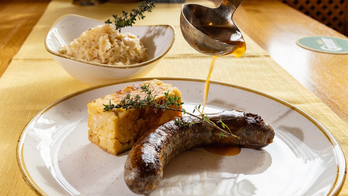 <p><p>Traditionelle Breinwurst mit Kümmelknödel und Sauerkraut, serviert mit frisch gegossenem Bratensaft im Gasthof Großschedl Zum Kramerwirt in Kainbach bei Graz. </p></p> | © Region Graz_Harry Schiffer