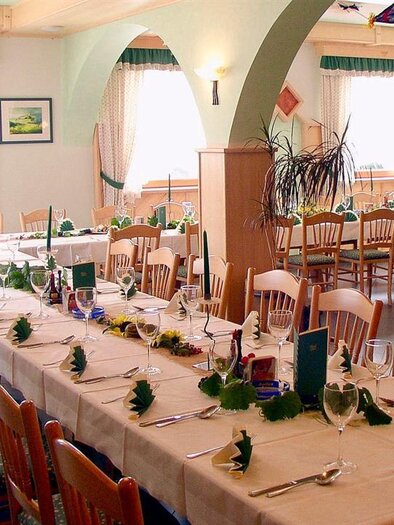 Ein festlich gedeckter Tisch in einem gemütlichen Raum. Helle Fenster sorgen für eine freundliche Atmosphäre. | © Herlwirt