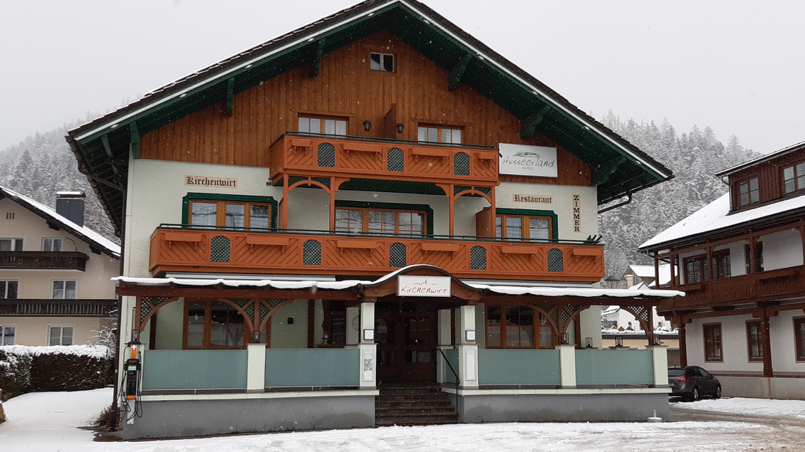 Ein traditionelles, mehrstöckiges Gebäude im alpenländischen Stil. Umgeben von Schnee und einer malerischen Berglandschaft. | © TVB Ausseerland Salzkammergut_Daniela Casari