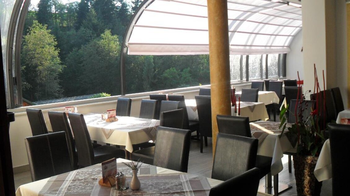 Ein Restaurant mit eleganten Tischen und Stühlen. Große Fenster bieten einen Blick auf die grüne Umgebung. | © Gasthof Klug "Zum Ehrensepp"