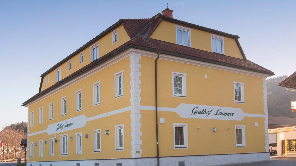 Ein gelbes Gebäude mit weißem Sockel und mehreren Fenstern. Das Hotel trägt die Aufschrift "Gasthof Lammer". | © TV Region Graz - Lunghammer