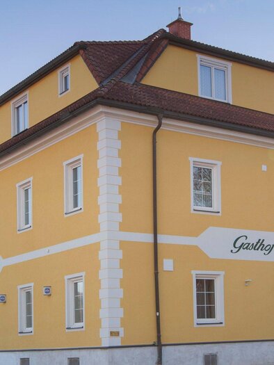 Ein gelbes Gebäude mit weißem Sockel und mehreren Fenstern. Das Hotel trägt die Aufschrift "Gasthof Lammer". | © TV Region Graz - Lunghammer
