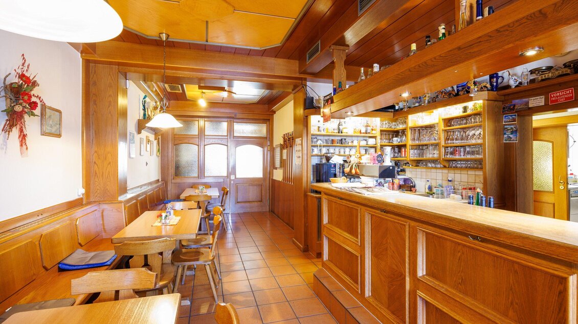 Ein gemütliches Restaurant mit Holzdekor und einer einladenden Bar. Die Tische sind für Gäste vorbereitet und schaffen eine angenehme Atmosphäre. | © TV Region Graz-Harry Schiffer