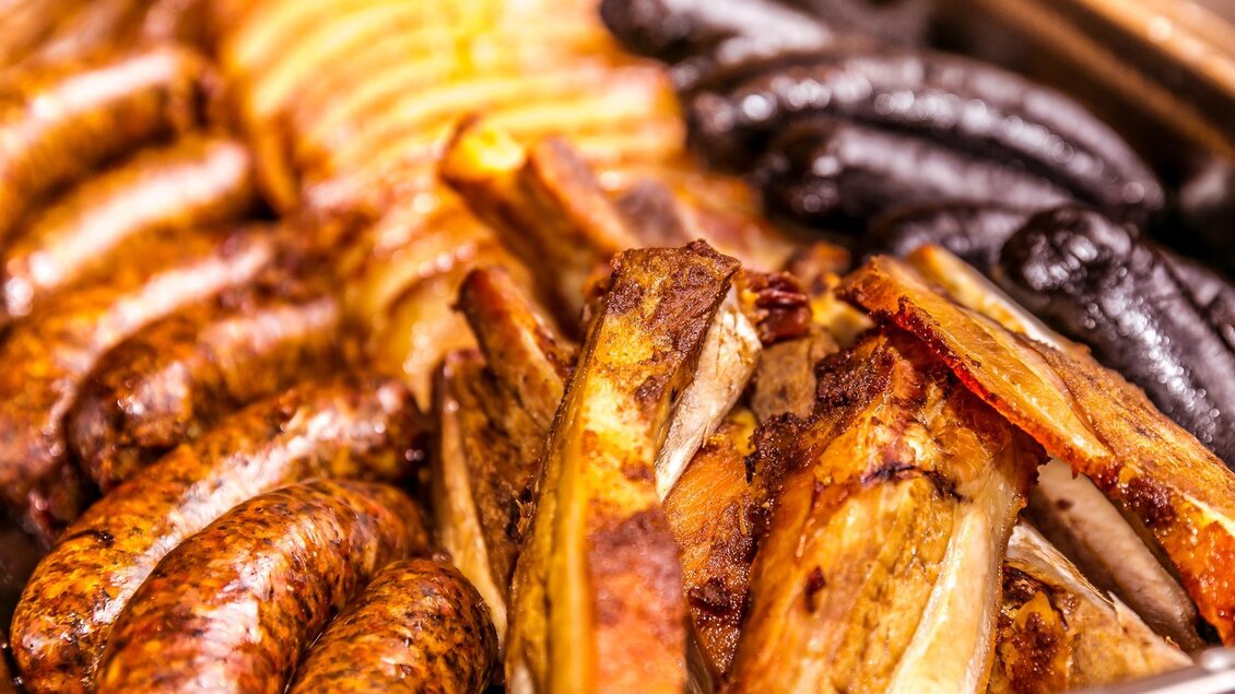 Eine Auswahl an gegrillten Würsten und Fleischstücken. Die verschiedenen Sorten sind appetitlich angerichtet. | © Gasthof Kranerwirt