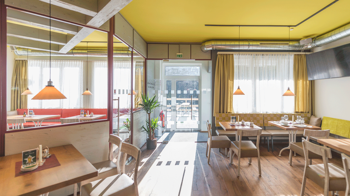 Ein modernes Restaurant mit einem hellen Innenraum und großen Fenstern. Die Möbel sind aus Holz und die Wände sind in warmen Farben gestaltet. | © TV Hochsteiermark