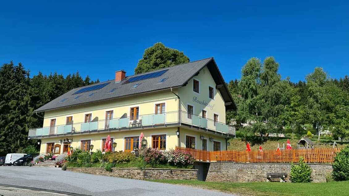 Ein attraktives Haus mit einem Balkon und Solaranlagen auf dem Dach. Die Umgebung ist grün und freundlich, ideal für einen ruhigen Aufenthalt. | © Gasthof Roschitzhof