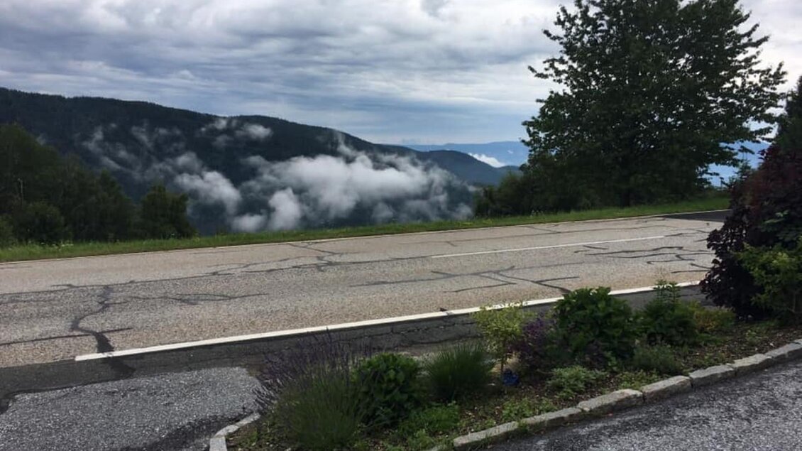 Eine ruhige Landstraße mit Blick auf bewaldete Berge und Wolken. Die Landschaft ist grün und lädt zum Verweilen ein. | © Gasthof Roschitzhof