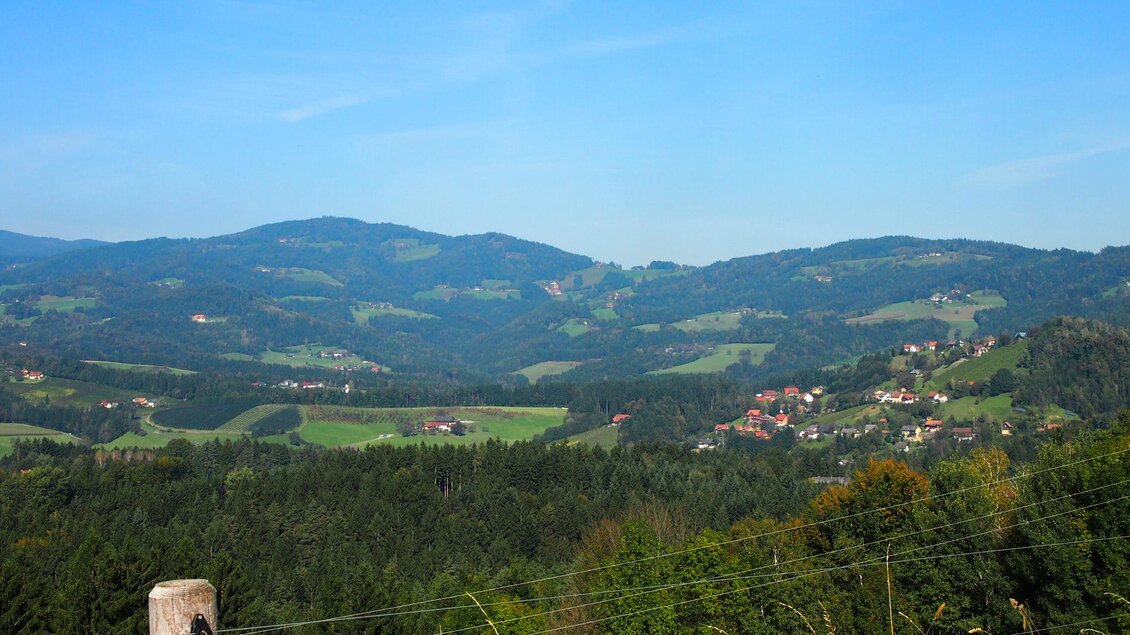 Eine sanfte Hügellandschaft mit grünen Feldern und kleinen Dörfern. Der Himmel ist blau und die Natur ist unberührt. | © GH Safran Filatsch