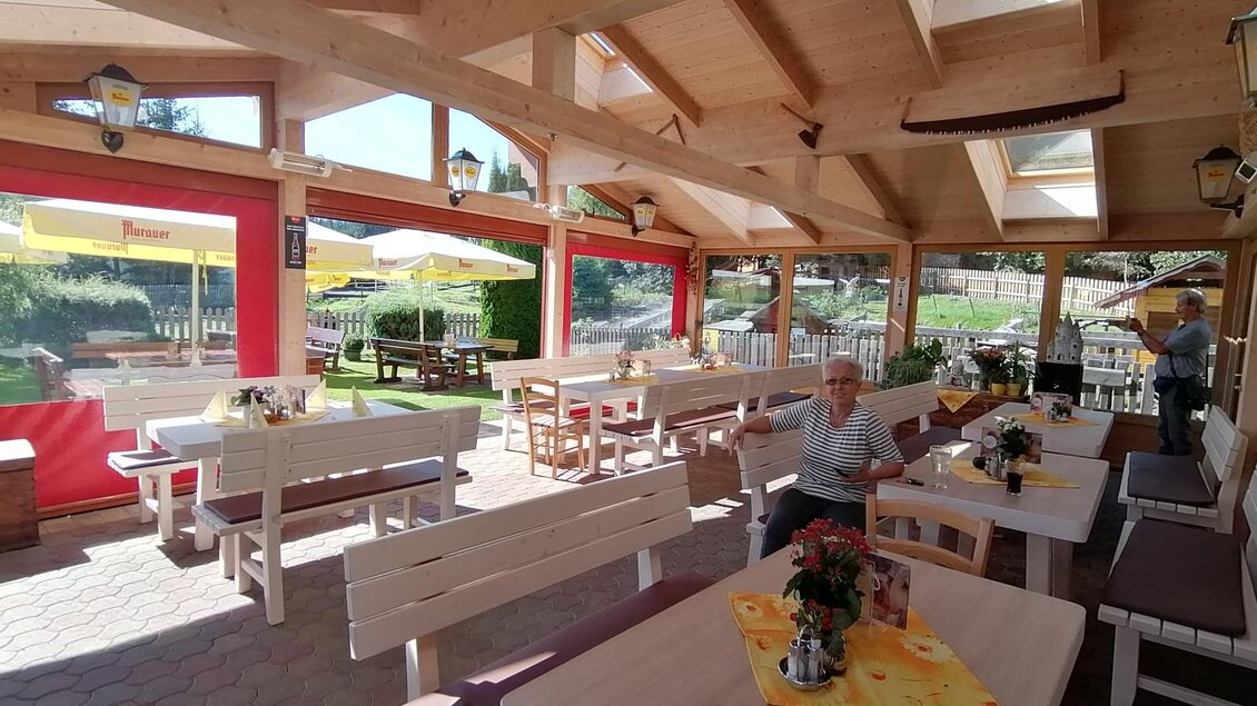 Ein helles Restaurant mit Holzdekor und großen Fenstern. Die Tischdecken sind mit Blumen geschmückt, und im Hintergrund ist ein schöner Außenbereich zu sehen. | © Gasthof Seeblick