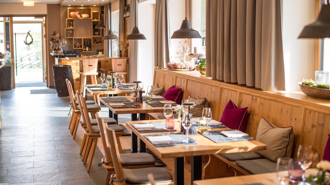 Ein einladendes Restaurant mit Holztischen und gemütlicher Atmosphäre. Große Fenster lassen viel Licht herein und schaffen eine freundliche Umgebung. | © Erlebnisregion Murtal