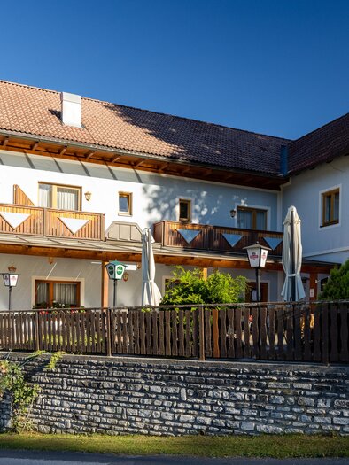 Ein gemütliches Gebäude mit Balkonen und einer freundlichen Atmosphäre. Es ist von einer gepflegten Gartenlandschaft umgeben. | © Lipizzanerheimat | Harry Schiffer
