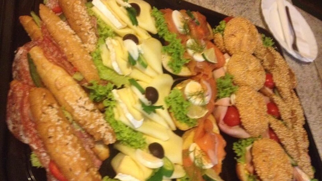 Ein platter mit verschiedenen belegten Brötchen und Sandwiches. Die Präsentation enthält frisches Gemüse und dekorative Elemente. | © Gaststätte Franz August