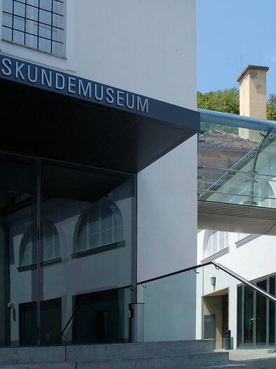 Entrance of the Folklore Museum with a modern glass promenade that connects the historical buildings. | © Volkskundemuseum