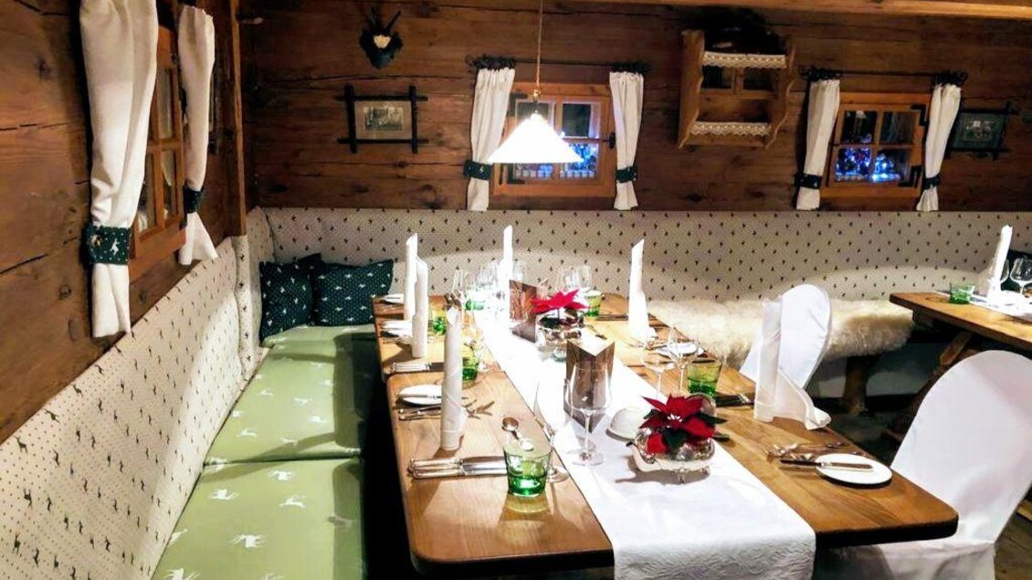 Ein gemütliches Restaurant mit Holzwänden und festlich gedeckten Tischen. Die Atmosphäre ist einladend, ideal für ein besonderes Abendessen. | © Dominik Utassy