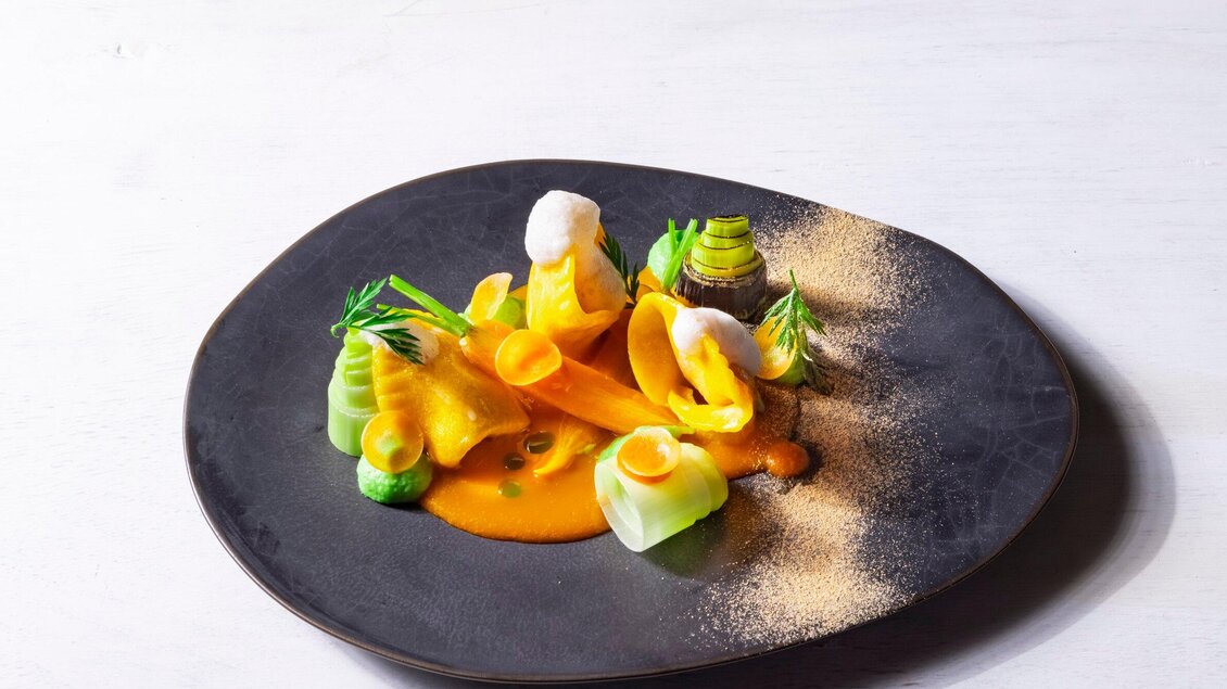 Ein kunstvoll angerichteter Teller mit buntem Gemüse und einer kräftigen Sauce. Die Präsentation ist modern und ansprechend. | © Genießerei am Markt - Werner Krug