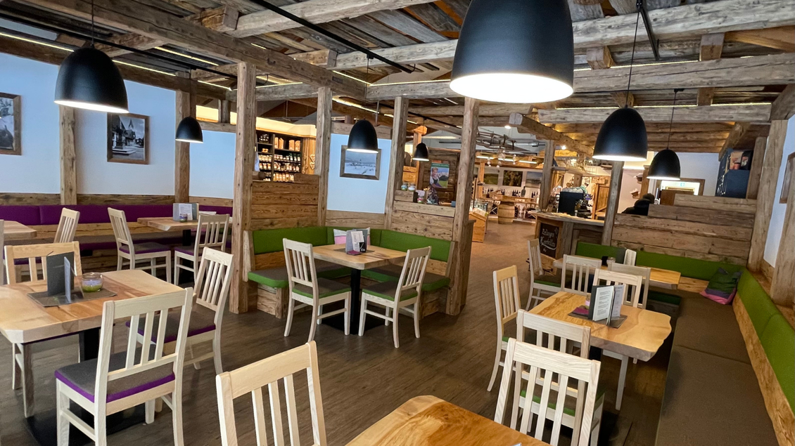 Ein gemütliches Restaurant mit Holzmöbeln und bunten Sitzbänken. Die Atmosphäre ist warm und einladend, perfekt für ein entspanntes Essen. | © Melanie Jos