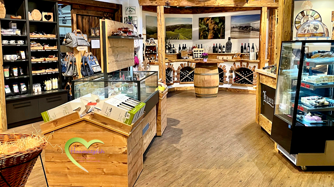 Ein einladender Geschäftsraum mit Holzregalen und Vitrinen. Produkte wie Wein und lokale Spezialitäten sind deutlich sichtbar. | © Melanie Jos