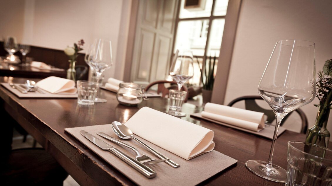 Ein elegant gedeckter Tisch in einem Restaurant. Gläser, Besteck und Servietten sind ordentlich platziert. | © Gerüchteküche