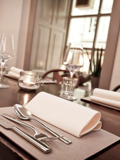 Ein elegant gedeckter Tisch in einem Restaurant. Gläser, Besteck und Servietten sind ordentlich platziert. | © Gerüchteküche