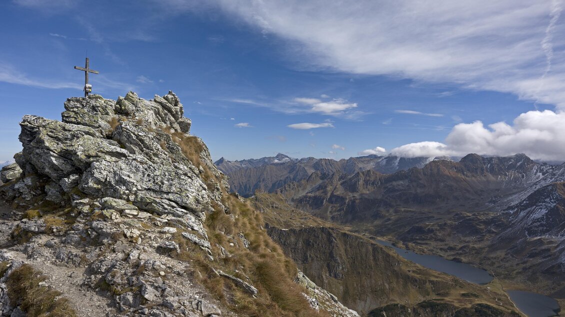 Eine beeindruckende Berglandschaft mit einer Felsformation im Vordergrund. Im Hintergrund sind hohe Berge und ein klarer Himmel zu sehen. | © Herbert Raffalt
