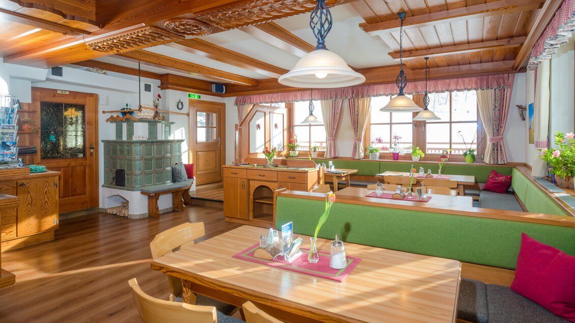 Ein gemütliches Restaurant mit Holzmöbeln und grünen Bänken. Das Licht ist freundlich und die Atmosphäre einladend. | © Glösalm