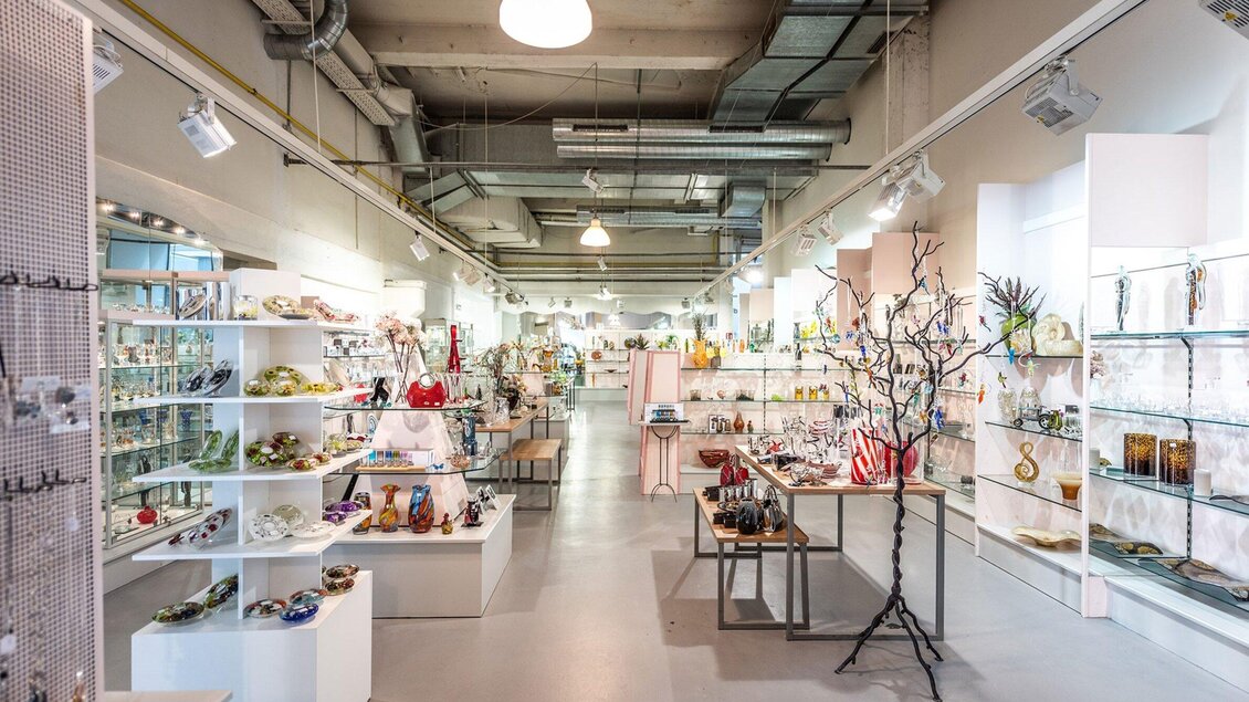 Ein helles Geschäft mit verschiedenen Ausstellungstischen. Es sind zahlreiche Kunstgegenstände und Dekorationen in den Regalen zu sehen. | © Die Abbilderei