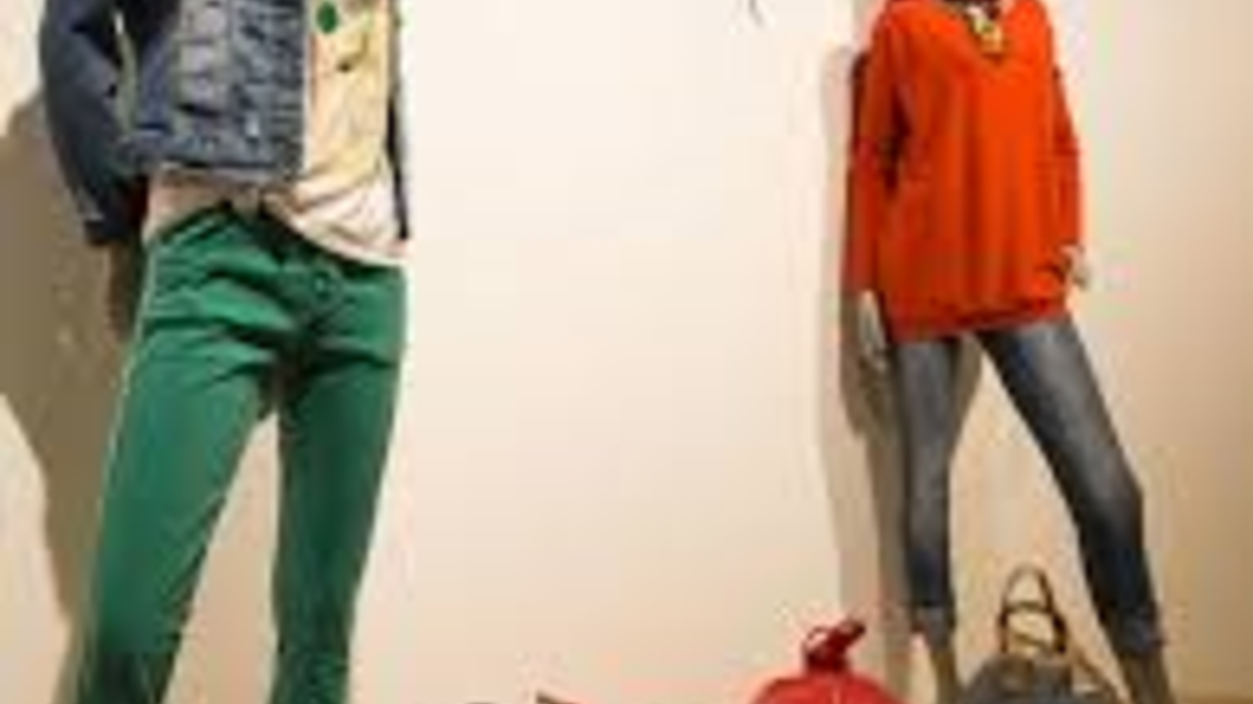 Eine modische Schaufensterdekoration mit zwei Schaufensterpuppen in bunter Kleidung. Dazu sind mehrere Taschen in verschiedenen Farben ausgestellt. | © Mode-Golf-Trendwear Judith Schraberger