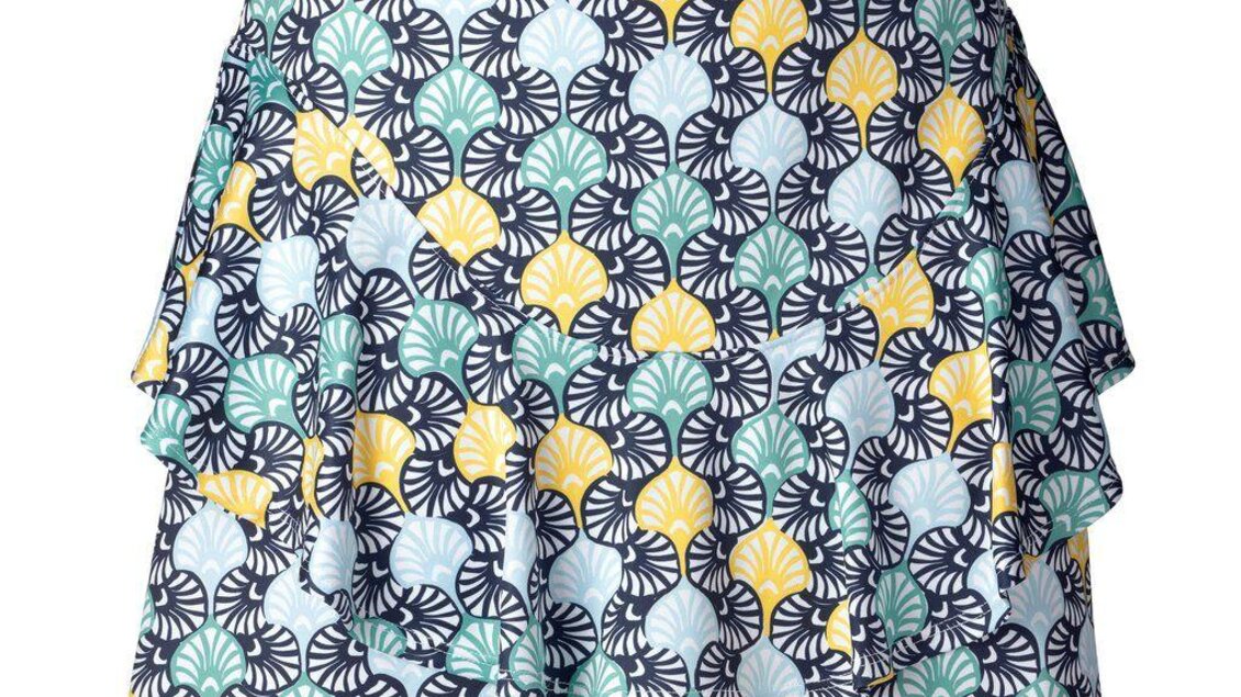 Ein kurzer Rock mit einem bunten Muschel-Muster in Gelb, Grün und Blau. Der Rock hat eine modische, geschichtete Gestaltung. | © Mode-Golf-Trendwear Judith Schraberger