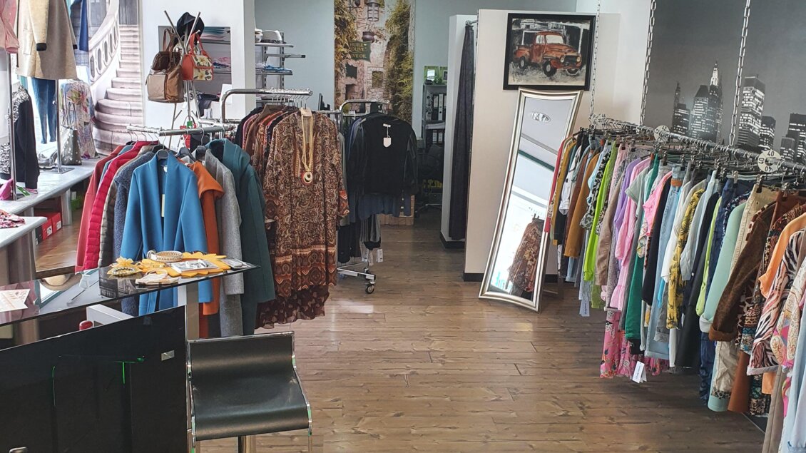 Ein modischer Laden mit bunten Kleidungsstücken an Kleiderständern. Der Raum hat einen modernen Stil mit Holzfußboden und einer hellen Atmosphäre. | © Golf-Fashion-Lifestyle Judith Schraberger